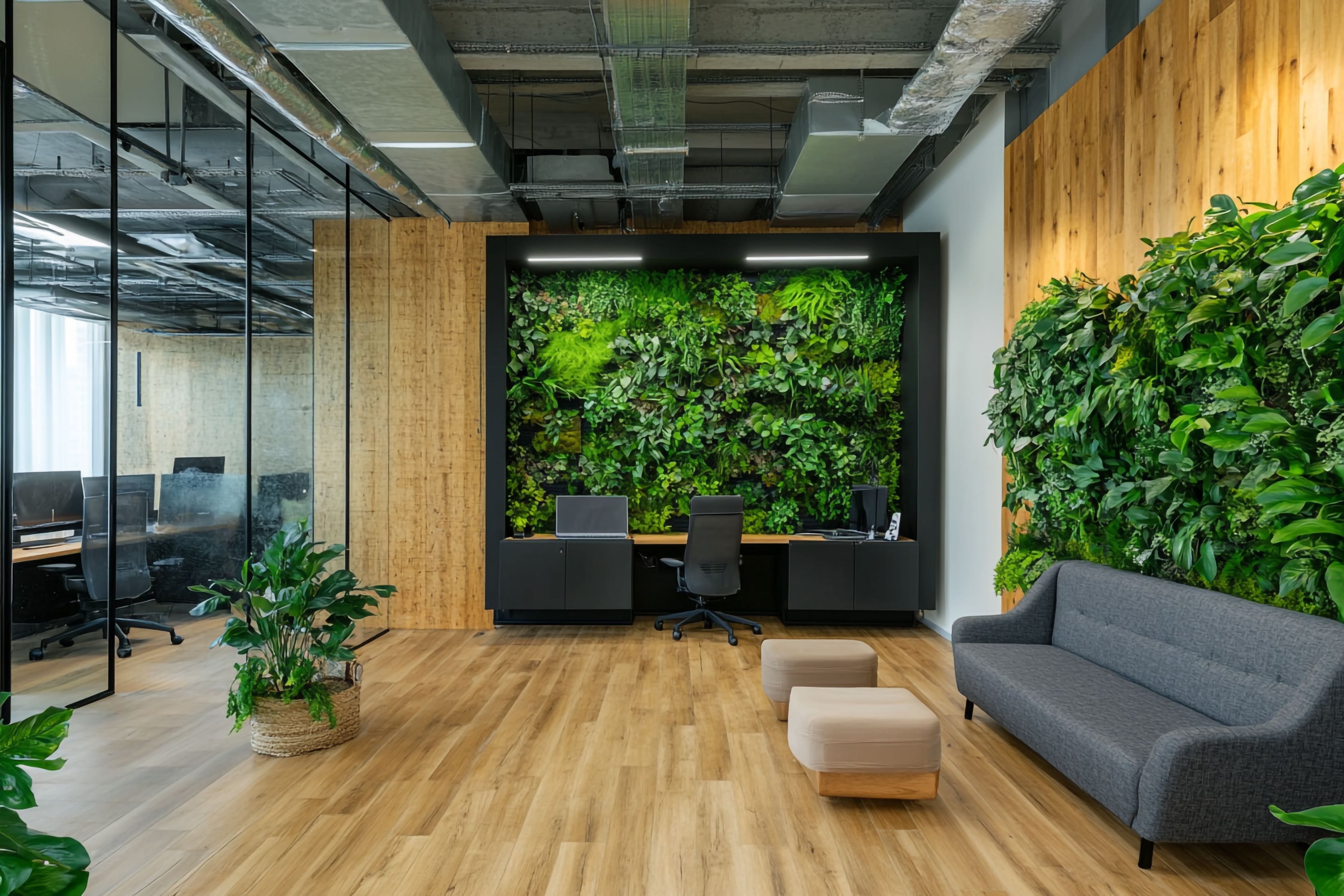 modern-office-with-green-wall-plants-wooden-floors-comfortable-seating